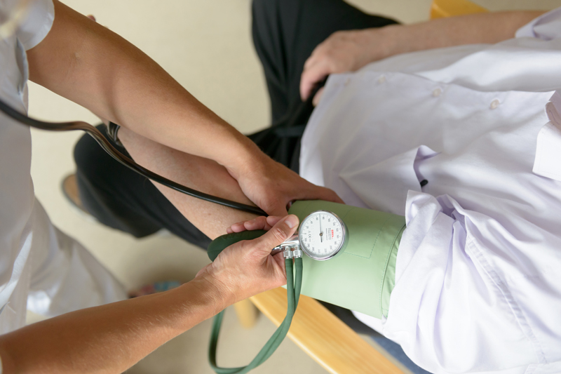 Ein Pfleger misst den Blutdruck bei einem Patienten