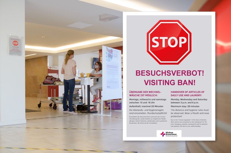 Der Besucherkontrollpunkt in der Lobby des Klinikums und das Schild zum Besuchsverbot