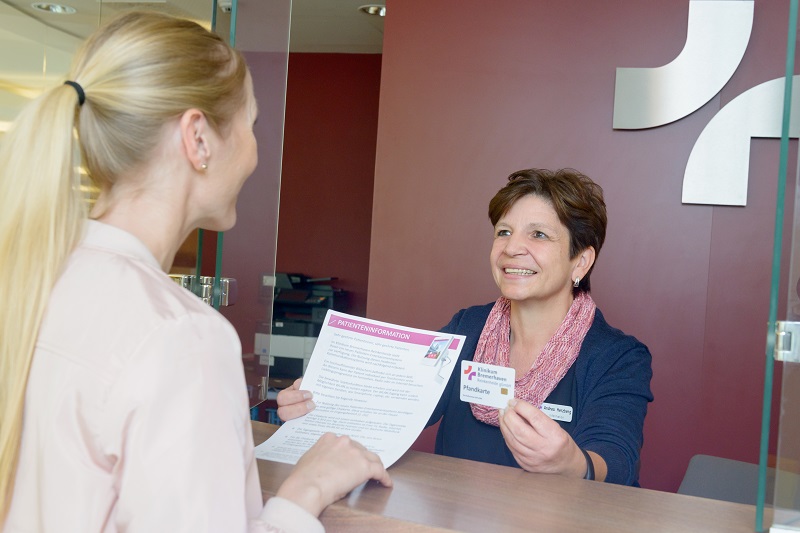 eine Patientin bei der Aufnahme erhält Informationen; verlinkt zur Seite 'Beratung und Service'