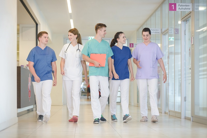 eine Gruppe von fünf jungen Pfegeauszubildenden geht nebeneinander auf einem Flur im Klinikum Bremerhaven-Reinkenheide eine Gruppe von fünf jungen Pfegeauszubildenden geht nebeneinander auf einem Flur im Klinikum Bremerhaven-Reinkenheide